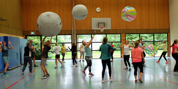 Sportlehrer*innen beim Spielen mit unterschiedlichen Bällen 