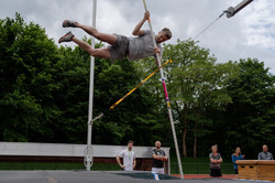 Tag des Schulsports 2022 Ein Teilnehmer führt einen Stabhochsprung über eine Zauberleine aus, während die anderen zuschauen