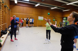 Teilnehmerinnen üben im Life-Kinetic-Workshop das überkreuzte Fangen zweier Bälle