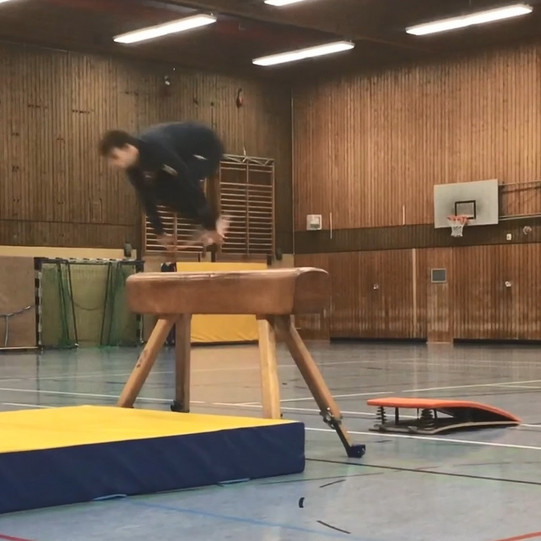 Sprunghocke Ein Studierender springt in der Sprunghocke über das Pferd.