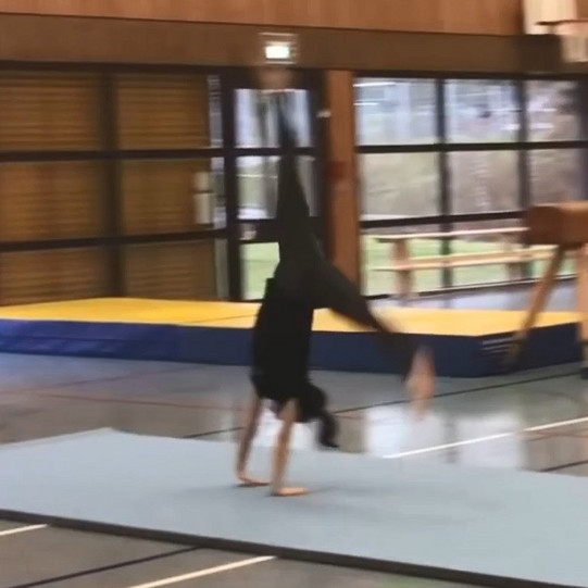 Rad mit Anlauf Eine Studierende schlägt ein Rad auf dem Bodenläufer.