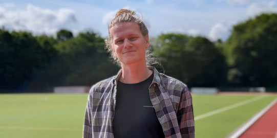 Portraitaufnahme Niklas Poß auf der Außenanlage