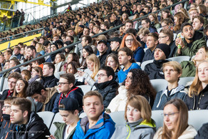 Studierende des ersten Semesters sitzen bei der Erstsemesterbegrüßung auf den Rängen im Stadium.