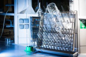 Beakers, graduated cylinders and volumetric flasks stand on a stand to dry.